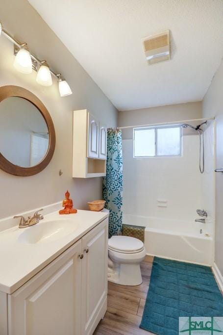 full bathroom featuring wood-type flooring, vanity, shower / tub combo, and toilet