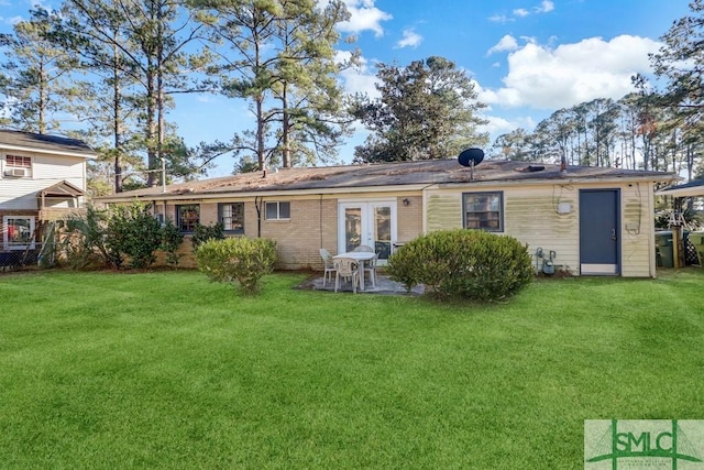 rear view of property featuring a yard and french doors