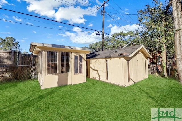 back of house with a storage shed and a lawn