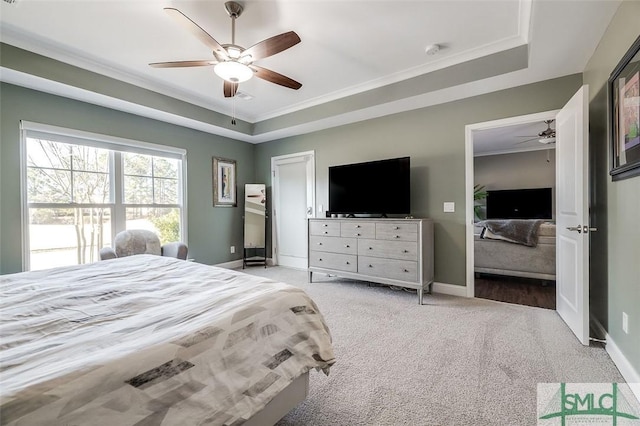 bedroom featuring a raised ceiling, ceiling fan, light carpet, and ornamental molding