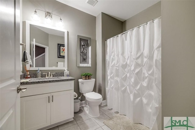 bathroom with tile patterned flooring, vanity, and toilet