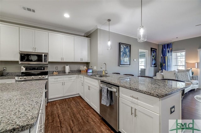 kitchen with white cabinetry, sink, stainless steel appliances, kitchen peninsula, and pendant lighting