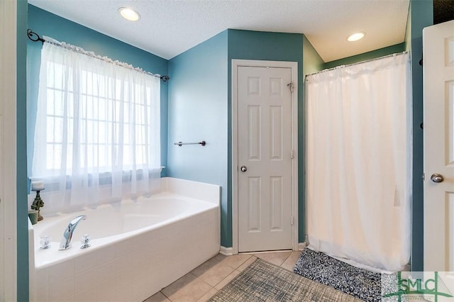 bathroom with tile patterned floors, separate shower and tub, and a textured ceiling