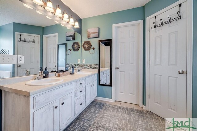 bathroom with tile patterned floors, vanity, and tasteful backsplash