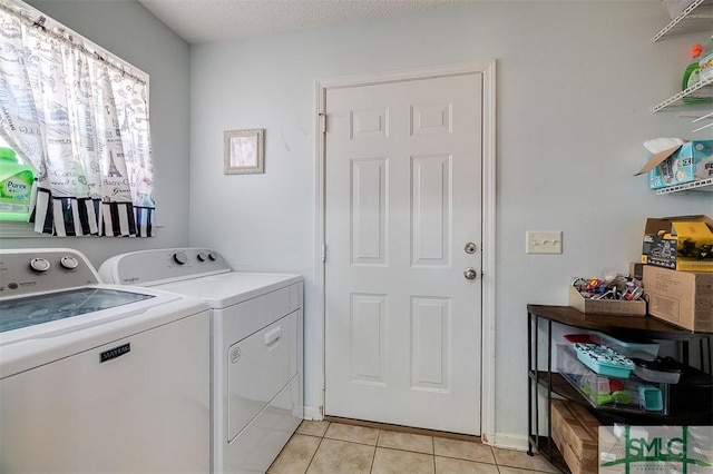 laundry area featuring independent washer and dryer, a textured ceiling, and light tile patterned floors