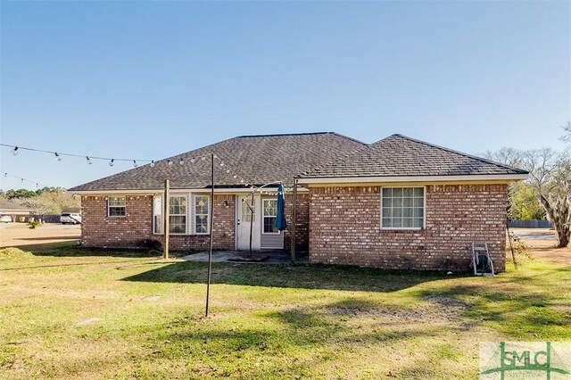 rear view of property featuring a lawn