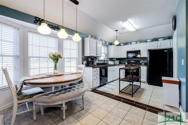 kitchen featuring pendant lighting, black appliances, white cabinets, decorative backsplash, and light tile patterned floors