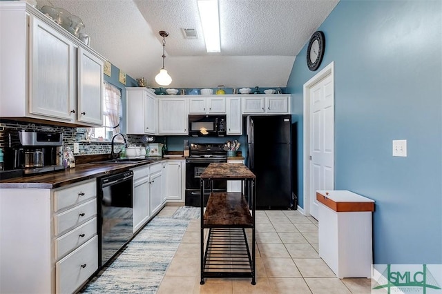 kitchen featuring lofted ceiling, black appliances, white cabinets, sink, and a textured ceiling