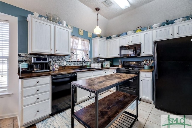 kitchen with black appliances, sink, vaulted ceiling, decorative light fixtures, and white cabinetry