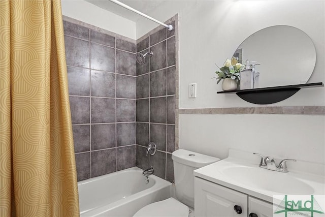 full bathroom featuring vanity, tiled shower / bath combo, and toilet