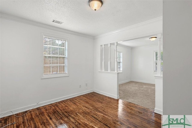 spare room with a textured ceiling, dark hardwood / wood-style floors, and crown molding