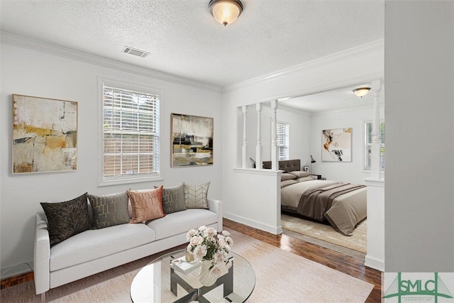 bedroom featuring crown molding, wood-type flooring, and a textured ceiling