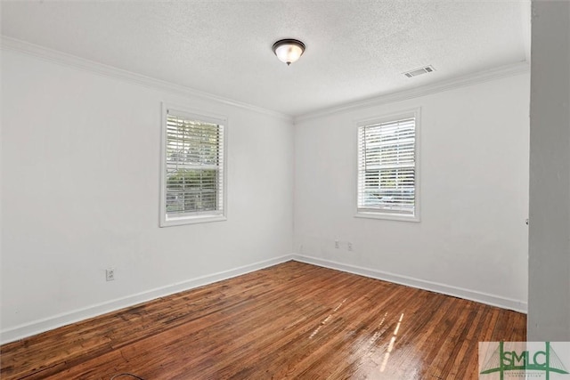 empty room featuring a textured ceiling, dark hardwood / wood-style floors, and crown molding