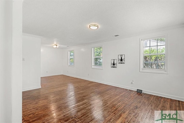 spare room with hardwood / wood-style floors, a textured ceiling, and crown molding