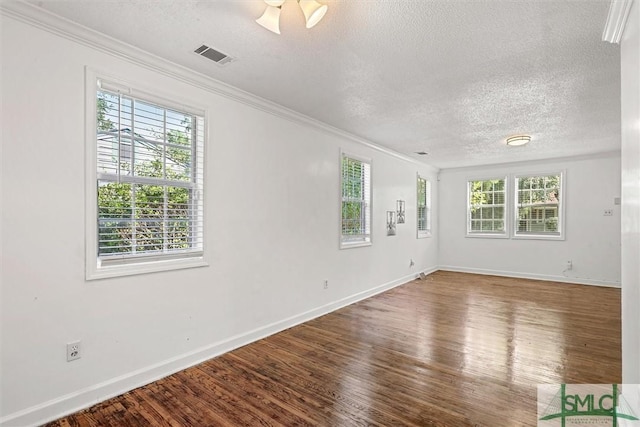 spare room with hardwood / wood-style floors, a textured ceiling, and crown molding