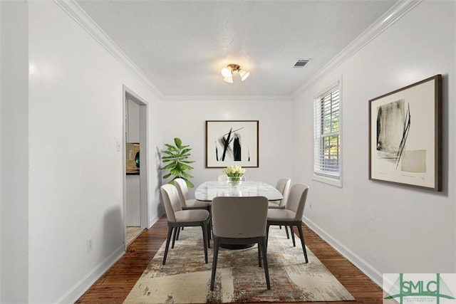 dining space with crown molding and dark wood-type flooring