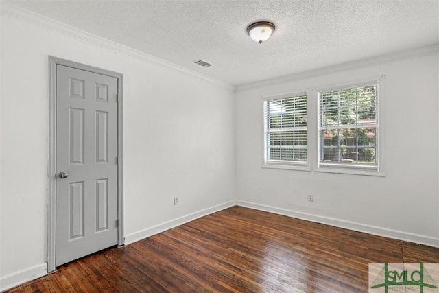 empty room with a textured ceiling, dark hardwood / wood-style floors, and ornamental molding