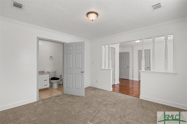 carpeted empty room featuring crown molding and a textured ceiling