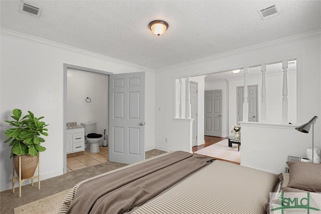 bedroom featuring light tile patterned floors, connected bathroom, a textured ceiling, and crown molding