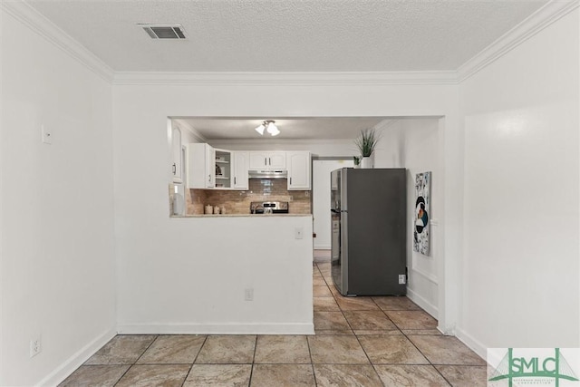 kitchen featuring decorative backsplash, appliances with stainless steel finishes, ornamental molding, a textured ceiling, and white cabinetry