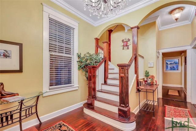 stairs with wood-type flooring, a notable chandelier, and ornamental molding