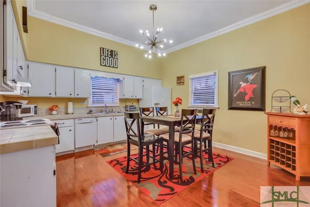 kitchen with tile countertops, white appliances, decorative light fixtures, and white cabinetry