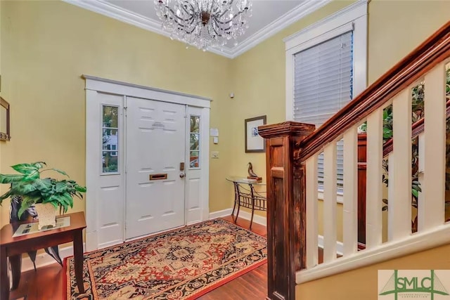 foyer featuring hardwood / wood-style flooring, a notable chandelier, and crown molding