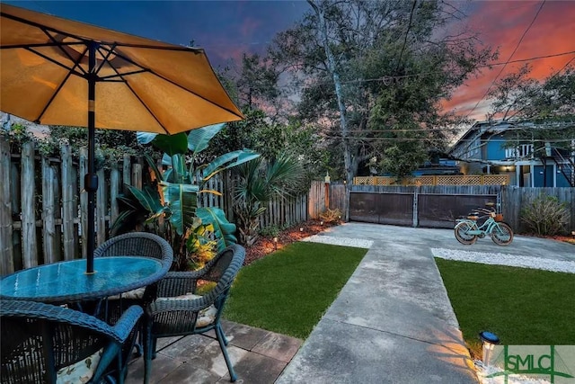 yard at dusk featuring a patio area