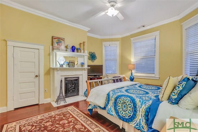 bedroom featuring hardwood / wood-style floors, ceiling fan, ornamental molding, and a closet