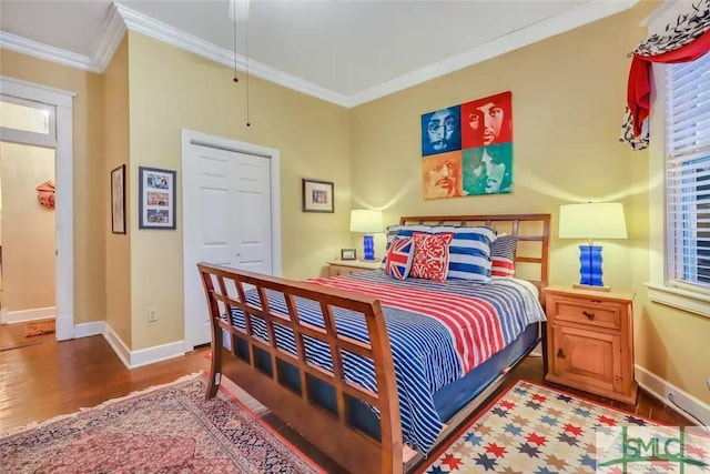 bedroom featuring hardwood / wood-style floors, a closet, ceiling fan, and crown molding