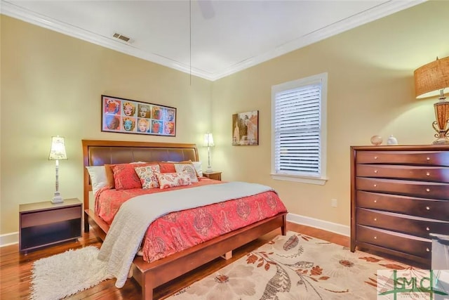 bedroom featuring ceiling fan, hardwood / wood-style floors, and ornamental molding