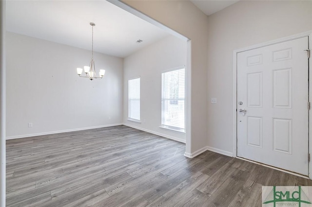 entryway with hardwood / wood-style flooring and an inviting chandelier