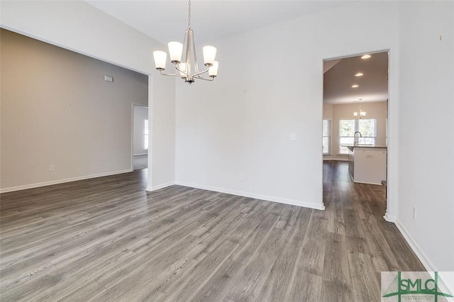 empty room featuring hardwood / wood-style floors, a chandelier, and sink