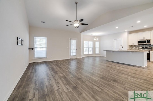 unfurnished living room featuring hardwood / wood-style floors, ceiling fan with notable chandelier, and lofted ceiling