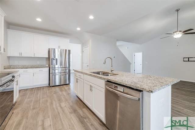 kitchen featuring white cabinetry, sink, stainless steel appliances, and a center island with sink