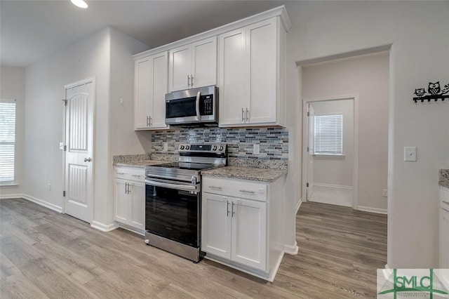 kitchen with plenty of natural light, white cabinets, and appliances with stainless steel finishes