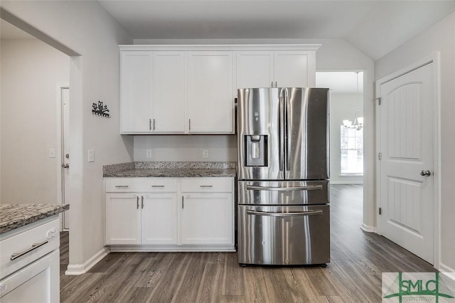 kitchen with stone counters, stainless steel refrigerator with ice dispenser, and white cabinetry