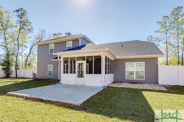 back of house featuring a sunroom, a patio area, and a lawn