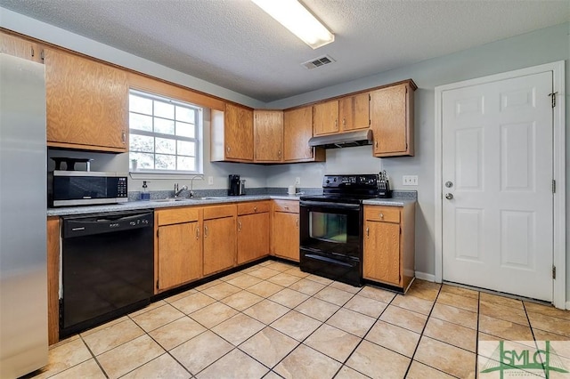 kitchen with black appliances, light tile patterned floors, sink, and a textured ceiling