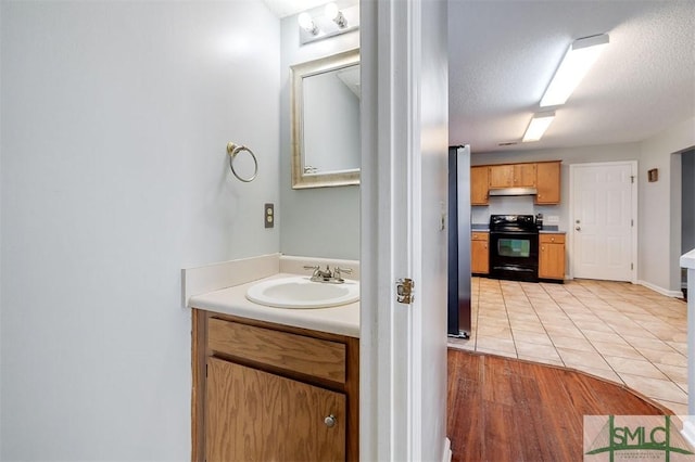 bathroom with tile patterned flooring, vanity, and a textured ceiling