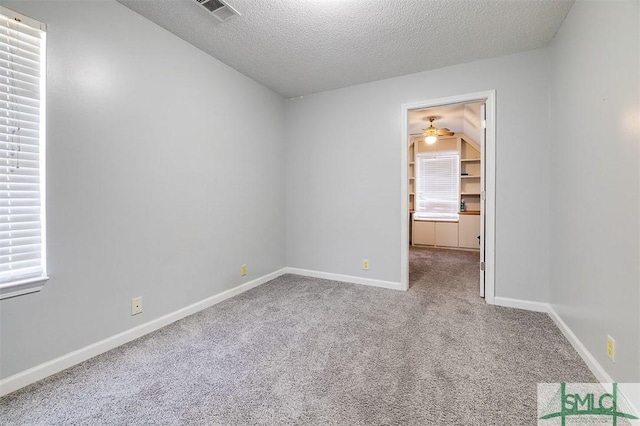 carpeted spare room with a textured ceiling