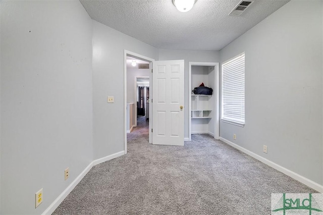 unfurnished bedroom with a textured ceiling and carpet floors