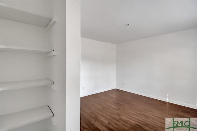 unfurnished room with dark wood-type flooring