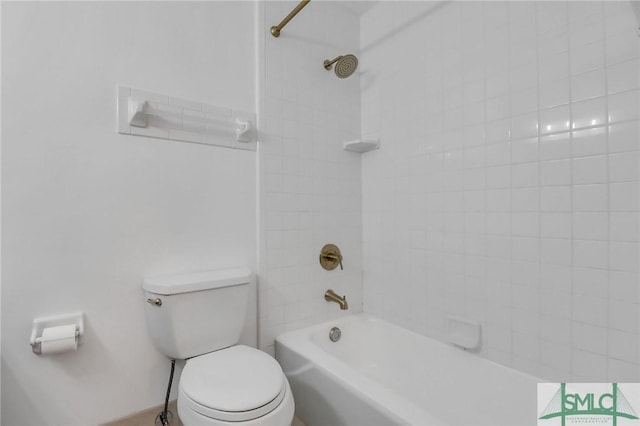 bathroom featuring tiled shower / bath combo and toilet