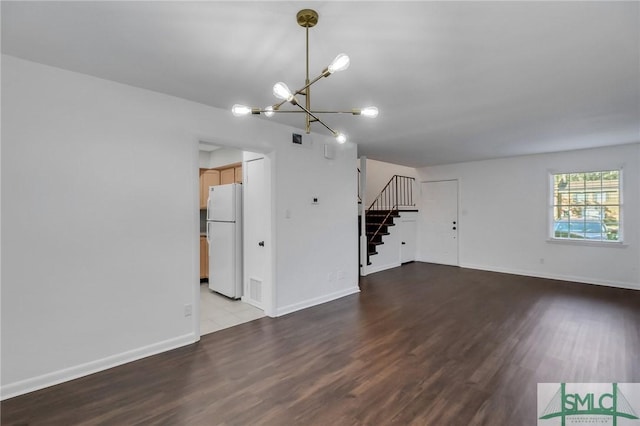 unfurnished living room with a chandelier and wood-type flooring