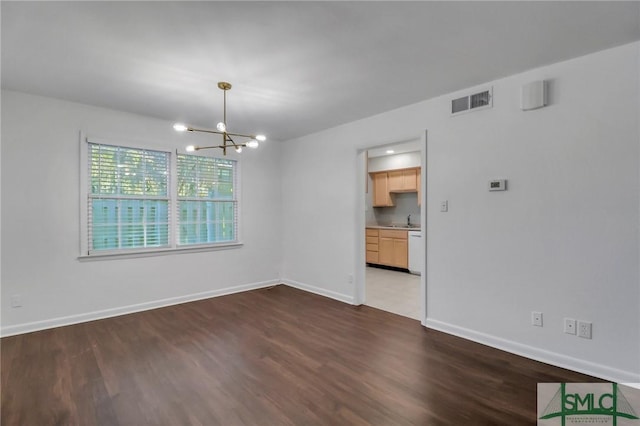 spare room with dark hardwood / wood-style flooring, a notable chandelier, and sink