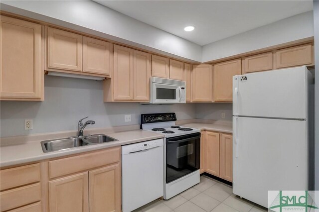 kitchen featuring light brown cabinets, white appliances, and sink