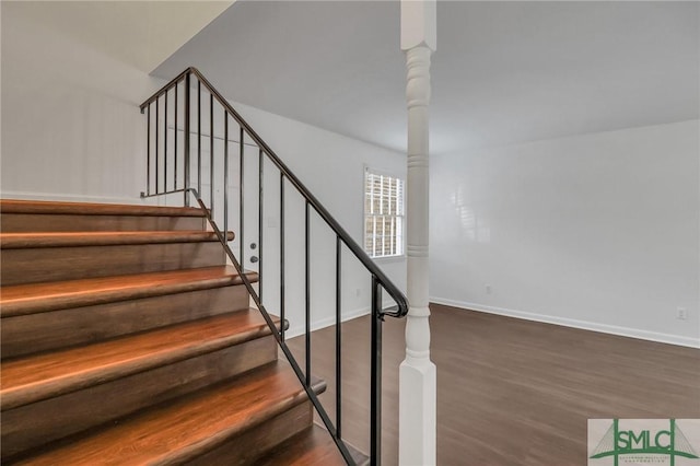 stairway featuring hardwood / wood-style floors and ornate columns