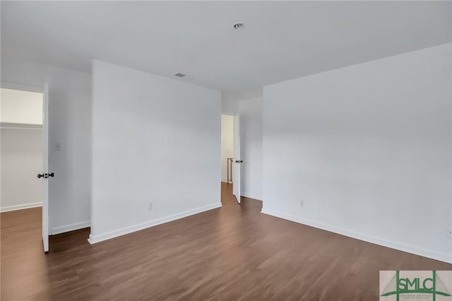 spare room with dark wood-type flooring