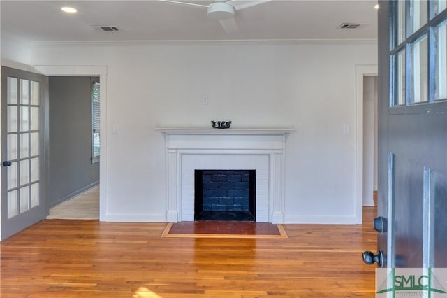 unfurnished living room with light hardwood / wood-style floors, crown molding, and a fireplace